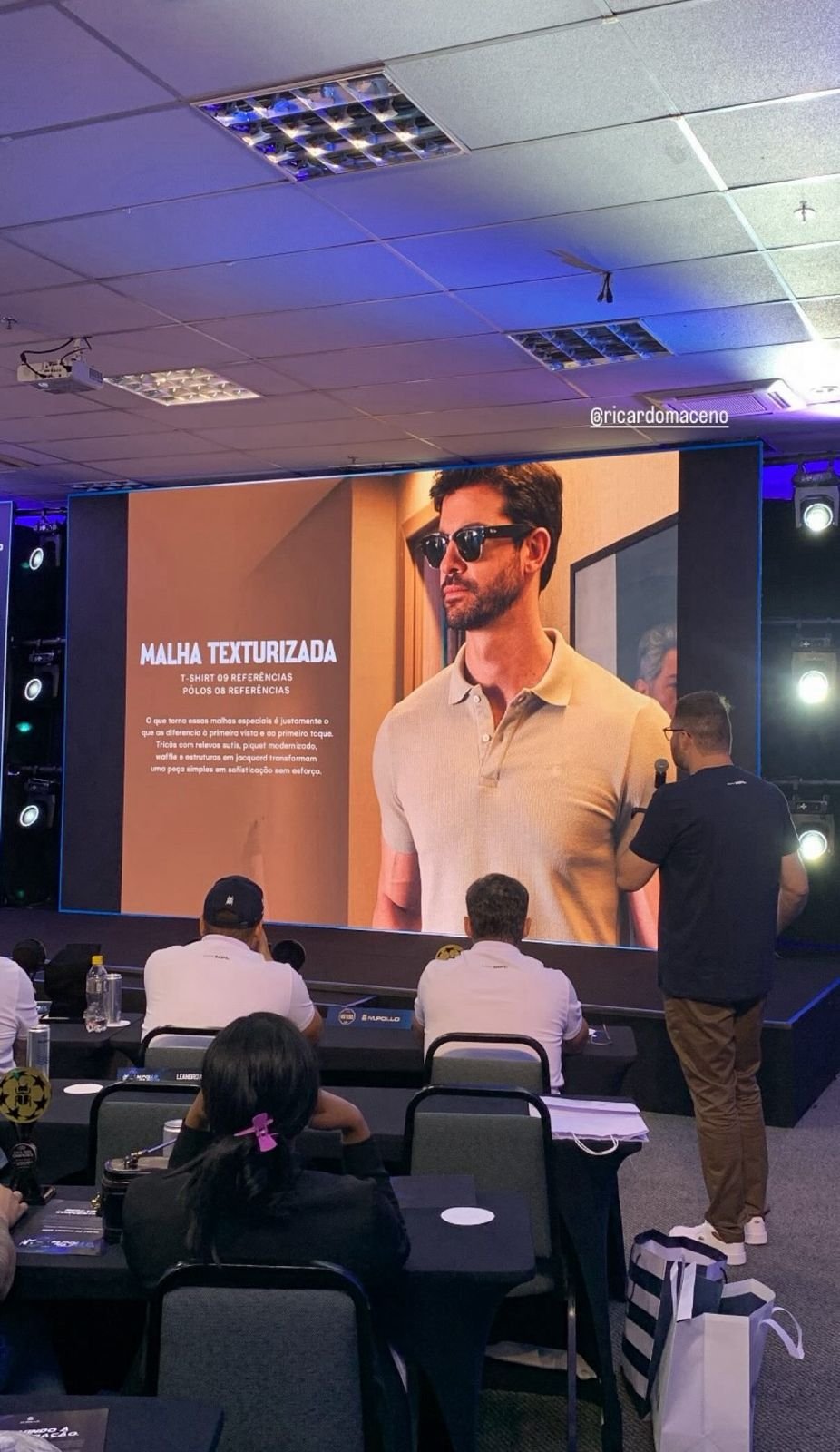 Ricardo Maceno no palco apresentando a coleção para a equipe